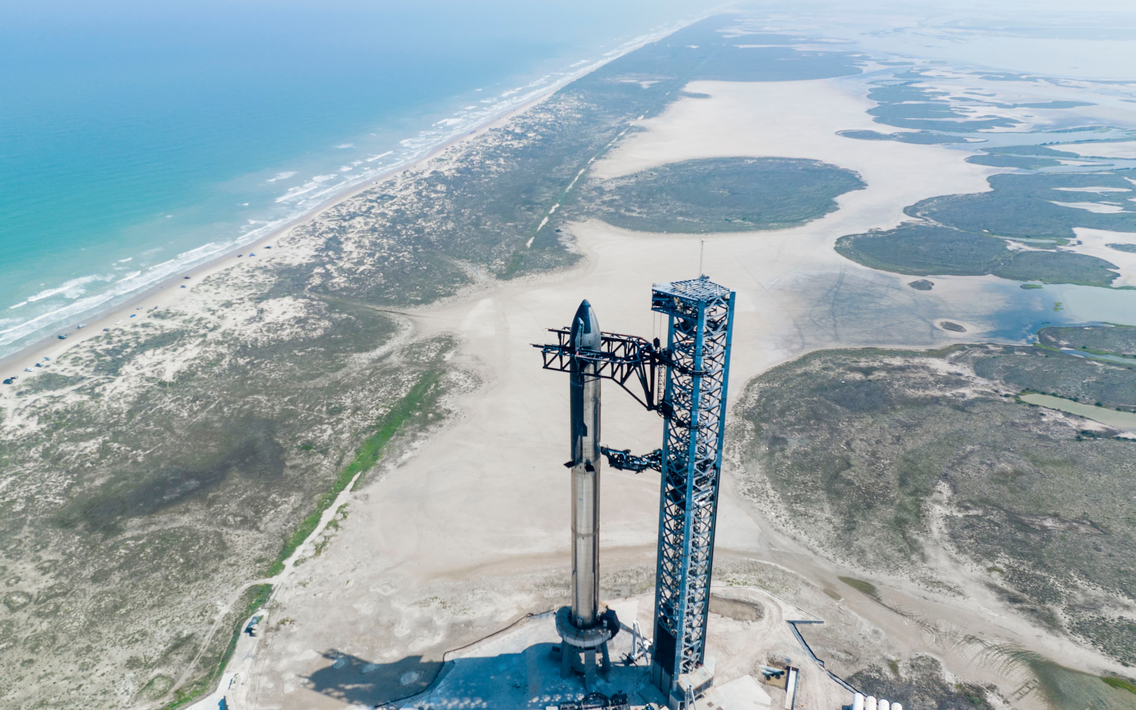 Heavy launch vehicle standing on a coastal launch pad viewed from above