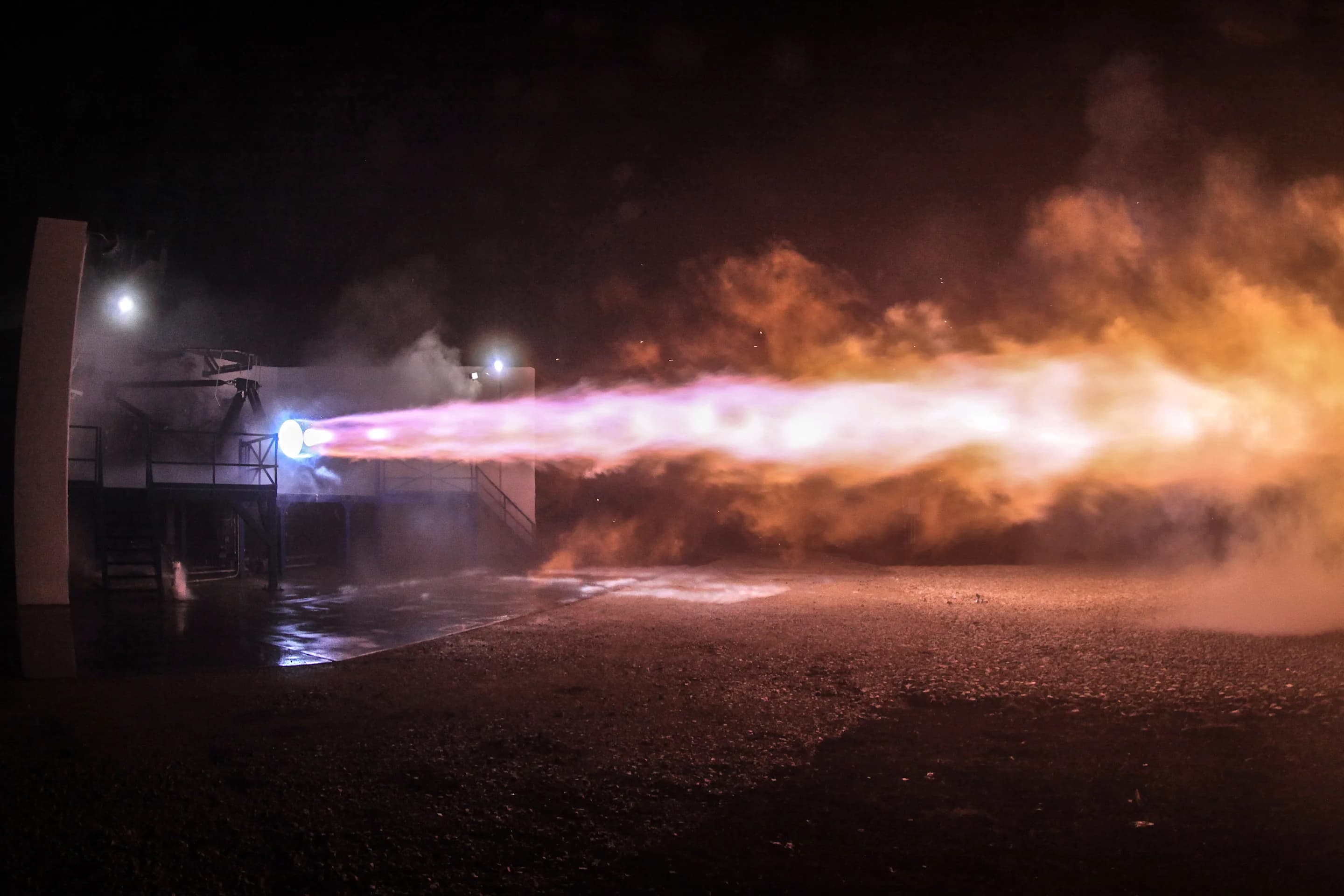 An early full-flow staged-combustion Raptor engine firing across a night test stand