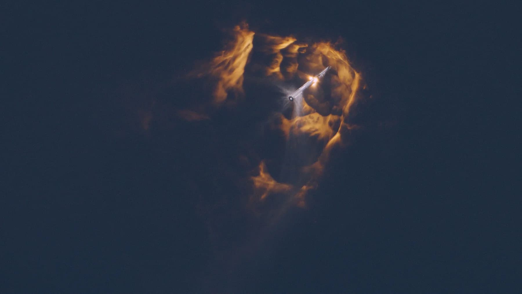 Launch vehicle ascending through a glowing high-altitude plume during orbital ascent